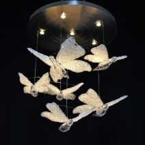 Lustre moderne artistique en strass - 6 papillons en cristal sous des spots lumineux