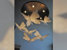 Lustre sur mesure - papillons suspendus à de fines cordes d'acier sous une plaque d'éclairage circulaire