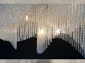 Détail des perles de verre et du métal d'un luminaire moderne